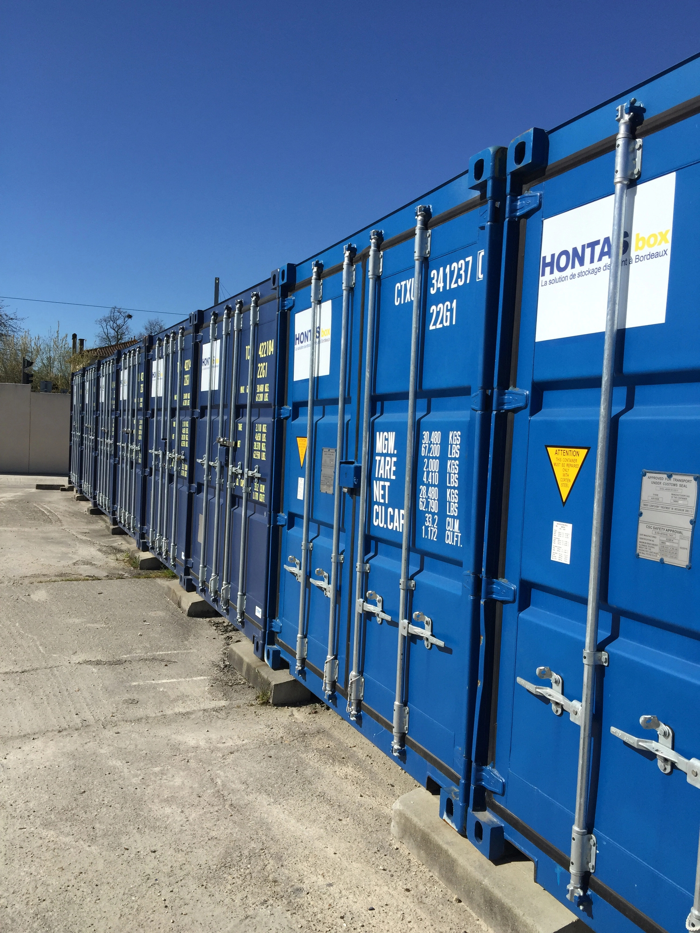 Professionnel avec transpalette chargeant des cartons dans un box de stockage sécurisé